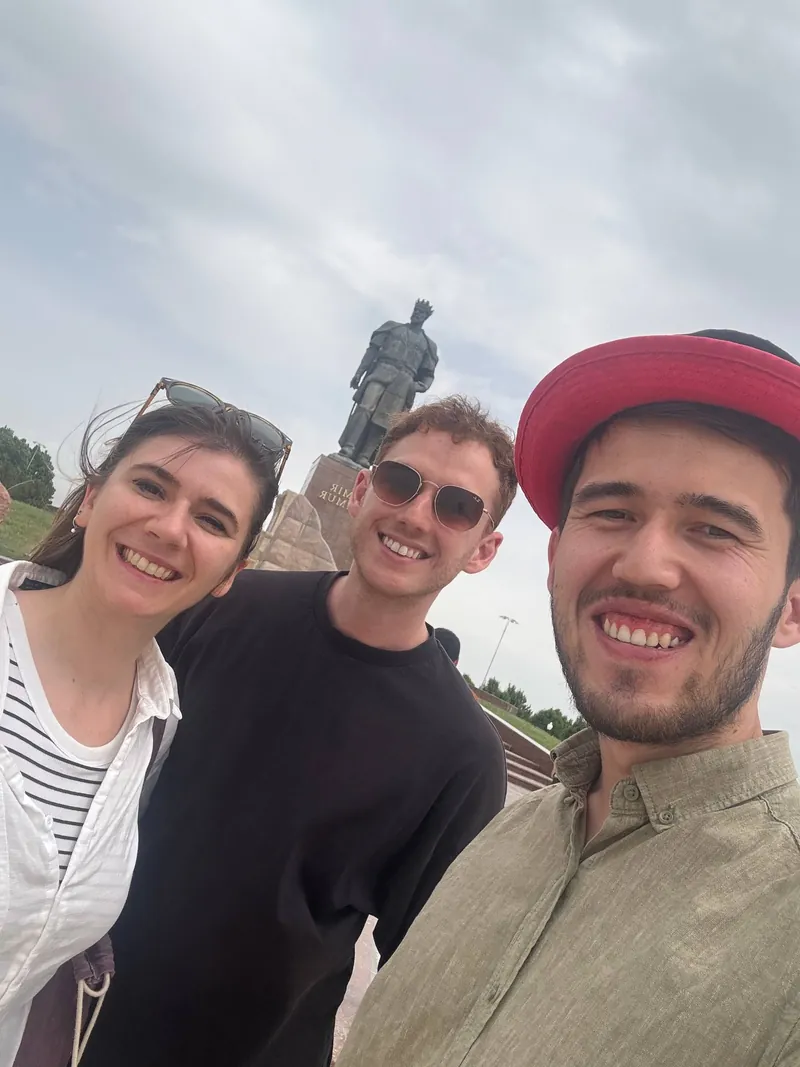 Our guide with two guests at the Amir Timur statue in Shakhrisabz